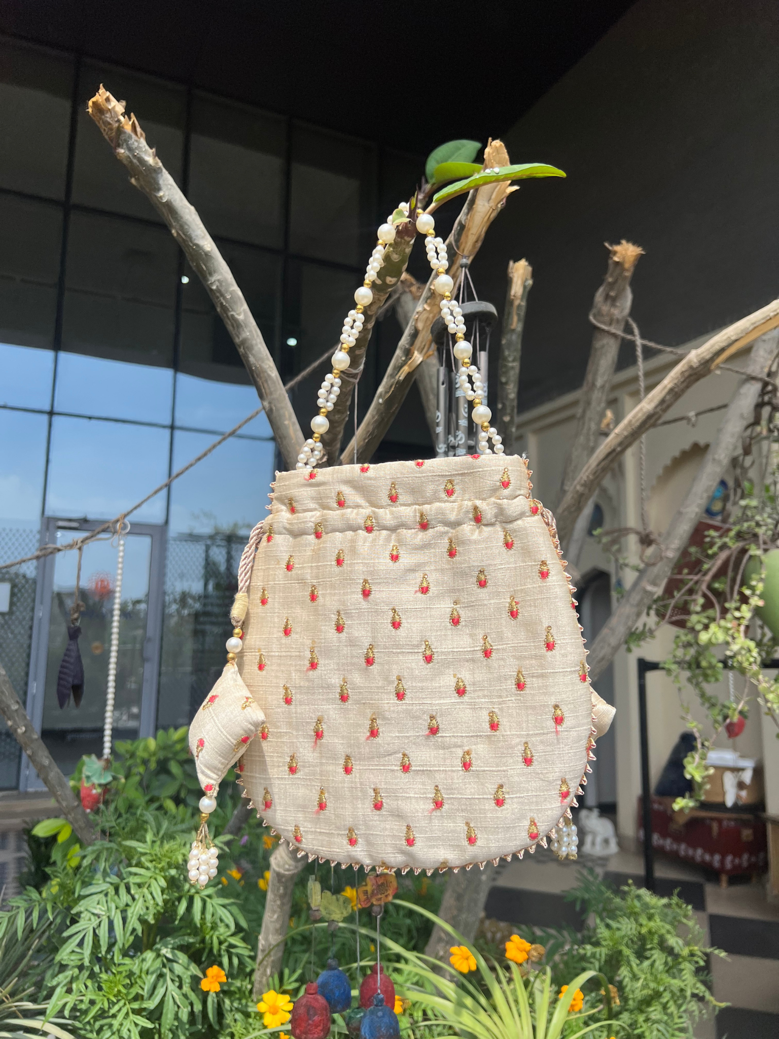 The Pearl-Encrusted Ivory Satin Potli bag.